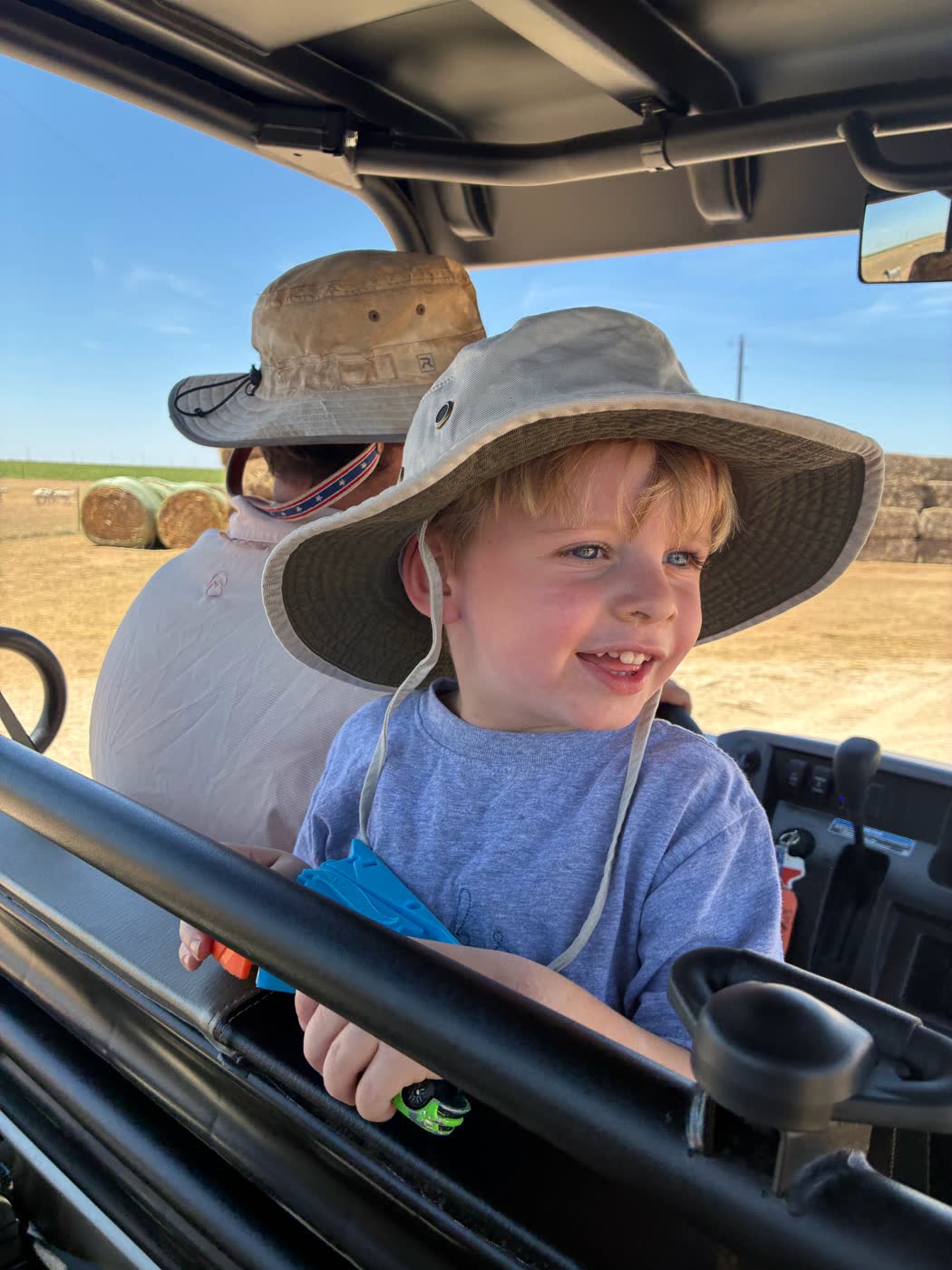 A boy in a hat, with a man behind him